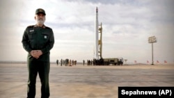General Amirali Hajizadeh, the head of the IRGC's aerospace division, stands in front of an Iranian rocket carrying a satellite in an undisclosed site on April 22.