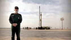 General Amir Ali Hajizadeh, the head of the Revolutionary Guard's aerospace division, stands in front of an Iranian rocket carrying a satellite in an undisclosed site believed to be in the Semnan province, Apeil 22, 2020