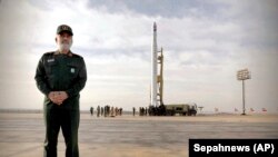 General Amir Ali Hajizadeh, the head of the Revolutionary Guard's aerospace division, stands in front of an Iranian rocket carrying a satellite in an undisclosed site believed to be in the Semnan province, Apeil 22, 2020