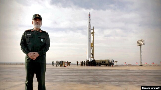 General Amir Ali Hajizadeh, the head of the Revolutionary Guard's aerospace division, stands in front of an Iranian rocket carrying a satellite in an undisclosed site believed to be in the Semnan province, Apeil 22, 2020