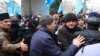 У центрі – Ахтем Чийгоз, заступник голови Меджлісу кримськотатарського народу, стримує натиск людей на мітингу 26 лютого 2014 року в Сімферополі