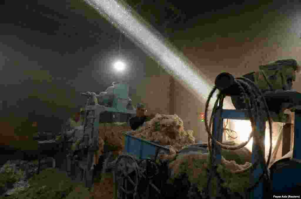 A laborer uses a piece of cloth as a mask to avoid dust while working at a cotton workshop in Peshawar, Pakistan. (Reuters/Fayaz Aziz)