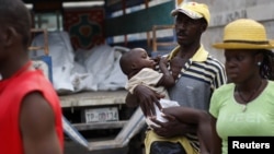 Гаити, на руках мужчины - ребенок с симптомами холеры