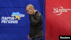 A man walks past the ruling Party of Regions (left) and Communist Party election campaign tents in Kyiv last week.