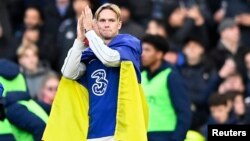 Mykhailo Mudryk applauded fans at halftime while wearing a Ukrainian flag during Chelsea's match against Crystal Palace on January 15. 