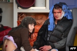 Раненые дожидаются скорой помощи после обстрела магазина в Куйбышевском районе Донецка, 8 октября
