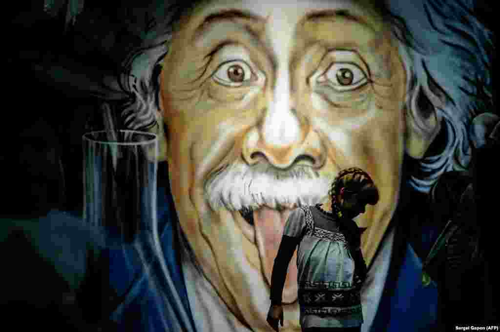 A girl walks in front of a mural depicting Albert Einstein at a museum designed to make science entertaining in Minsk. (AFP/Sergei Gapon)