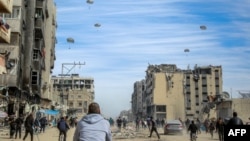 Palestinezët duke ngarendur pas ndihmave humanitare të hedhura nga ajri në Qytetin e Gazës më 1 mars 2024.
