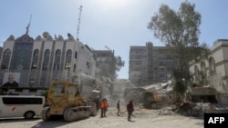 Rescue workers search the rubble of a building annexed to the Iranian Embassy a day after an air strike in Damascus on April 2.