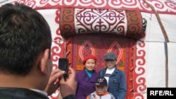 Семья фотографируется на фоне юрты во время празднования Наурыза. Алматы, 22 марта 2009 года.