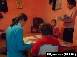 Дети Кайырбека и Карлыгаш Дарибаевых готовят уроки в комнате, где и живет эта многодетная семья. Шымкент, 5 декабря 2015 года.