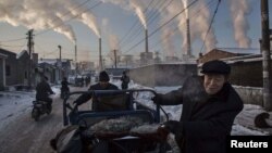 FILE: Chinese men pull a tricycle in a neighborhood next to a coal-fired power plant in Shanxi, China. , November 26, 2015. The county with a history of heavy dependence on burning coal for energy is now helping Pakistan to follow in its footsteps.