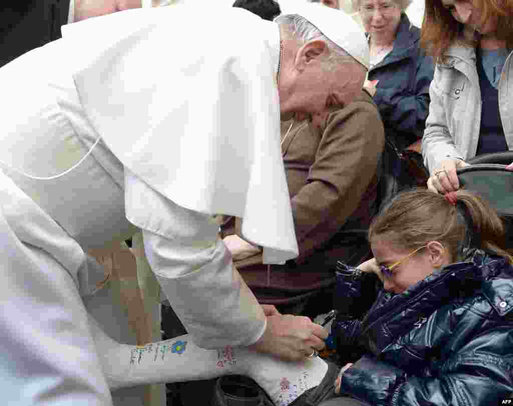 Папа Франциск пише на гіпсовій пов&rsquo;язці молодої дівчини під час своєї щотижневої аудієнції на площі Святого Петра на у Ватикані, 3 квітня 2013 року.