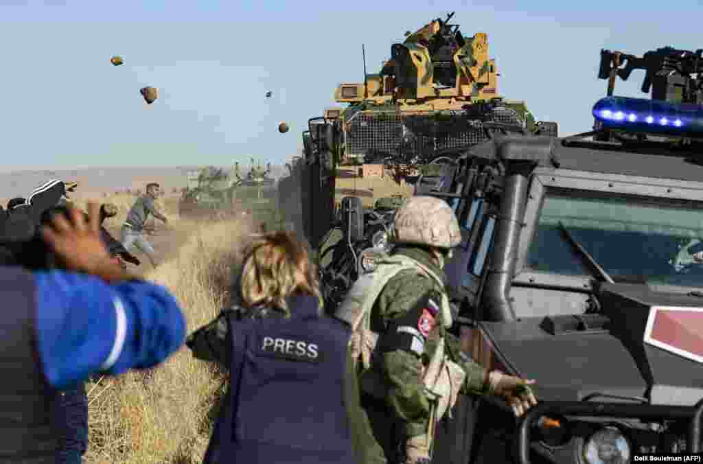 Kurdish demonstrators hurl rocks at a Turkish military vehicle during a joint Turkish-Russian patrol near the town of Al-Muabbadah in the northeastern part of Hassakah on the Syrian border with Turkey on November 8.&nbsp;(AFP/Delil Souleiman)