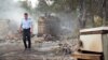 A police officer inspects burned-out houses in the village of Chelopek, North Macedonia, on August 5. 