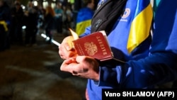 Un protestatar din Tbilisi, Georgia dă foc pașaportului rusesc, în semn de protest față de bombardamentele rusești asupra Ucrainei.