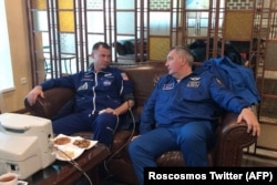 Roskosmos chief Dmitry Rogozin (right) sits next to NASA astronaut Nick Hague as he undergoes a medical examination in Zhezqazghan after the aborted flight.