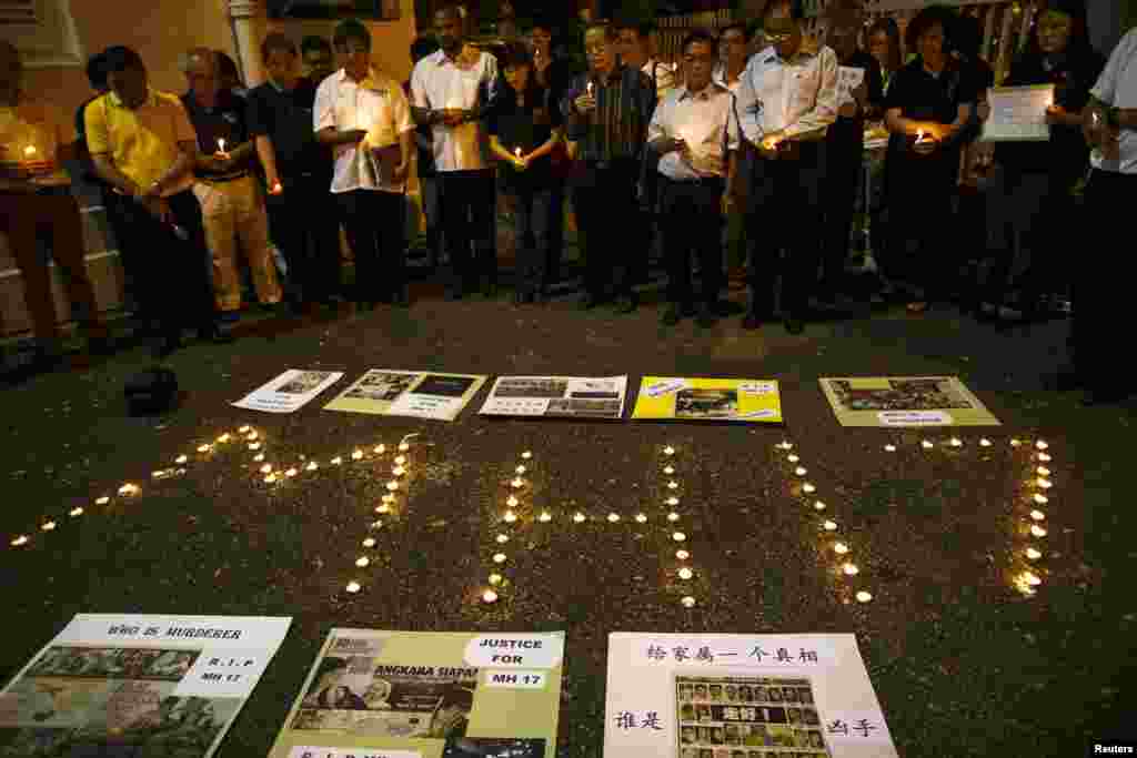 People hold candles during a candlelight vigil for victims of the downed Malaysia Airlines Flight MH17, in Kuala Lumpur on July 19.&nbsp;