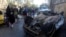 Iraqis gather at the site of a car bombing in the Shuala area of Baghdad on January 30.