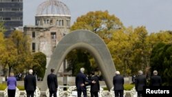 U.S. Secretary of State John Kerry (center-left) puts his arm around Japanese Foreign Minister Fumio Kishida after they and fellow G7 foreign ministers laid wreaths at the cenotaph at the Hiroshima Peace Memorial Park and Museum in Hiroshima.