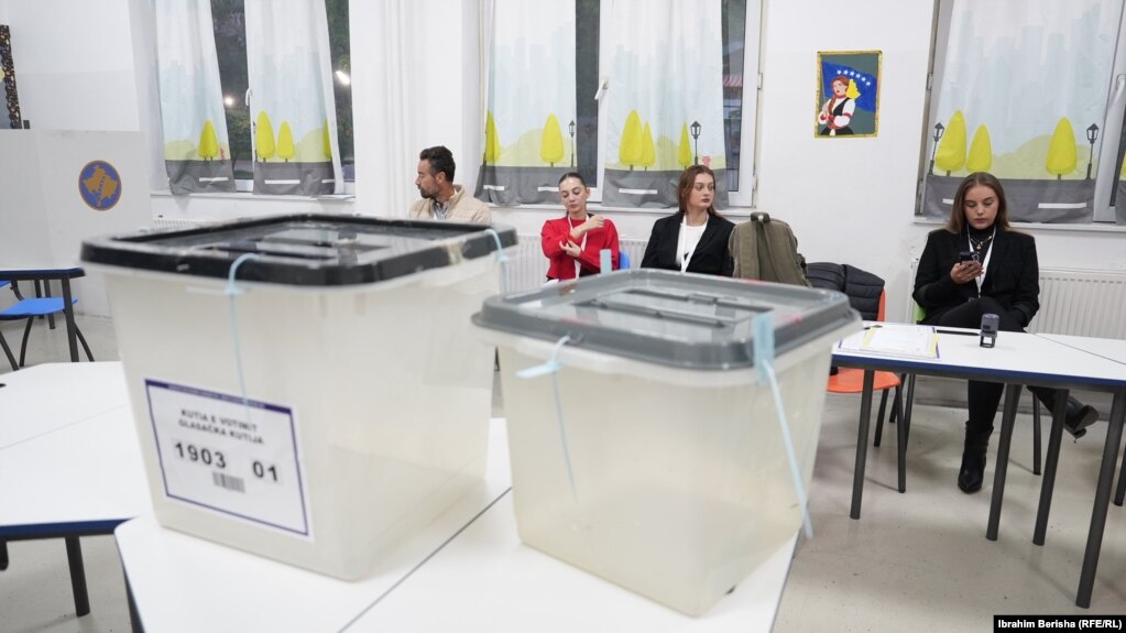 Zyrtare të Komisionit Qendror të Zgjedhjeve shikojnë teksa presin në një qendër votimi në Prishtinë ardhjen e votuesve për ta hedhur votën e tyre në zgjedhjet lokale të Kosovës, 12 tetor 2025.