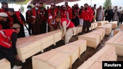 د سرې میاشتې ټولنې کارکوونکي د کابل پر روغتون په برید کې د وژل شویو تابوتونه لېږدوي - د مارچ ۱۸مې انځور.