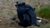 A mine detection worker with the HALO Trust demining NGO searches for antitank and antipersonnel land mines in Lypivka, on the outskirts of Kyiv in June 2022. 