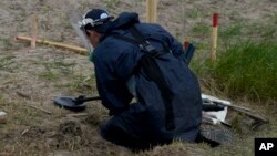 A mine detection worker with the HALO Trust demining NGO searches for antitank and antipersonnel land mines in Lypivka, on the outskirts of Kyiv in June 2022. 