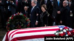 ԱՄՆ - Նախկին նախագահ Ջորջ Բուշը կրտսերը տիկնոջ՝ Լաուրայի հետ հարգանքի տուրք է մատուցում հորը՝ նախկին նախագահ Ջորջ Բուշ ավագին, Կապիտոլիում, Վաշինգտոն, 3-ը դեկտեմբերի, 2018թ.