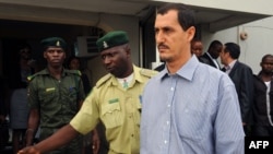 Reputed Iranian Revolutionary Guards Corps member Azim Aghajani (right) is led away after his conviction for illegal arms trafficking in the Federal High Court in Lagos on May 13.