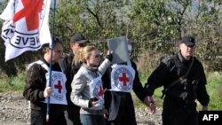 Armenia -- International Committee of the Red Cross officials carry their flag as they follow Armenian servicemen repatriating Eldar Tagiyev, an Azerbaijani civilian, near the village of Kayan, 04Nov2010