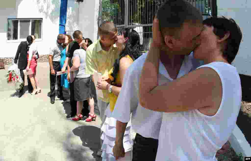 Just-married couples kiss during their wedding ceremony in a men&#39;s prison colony in the Donetsk region of Ukraine. The wedding of the six prisoners with their unrestricted girlfriends was organized by the prison administration. (AFP/Alexander Khudoteply)