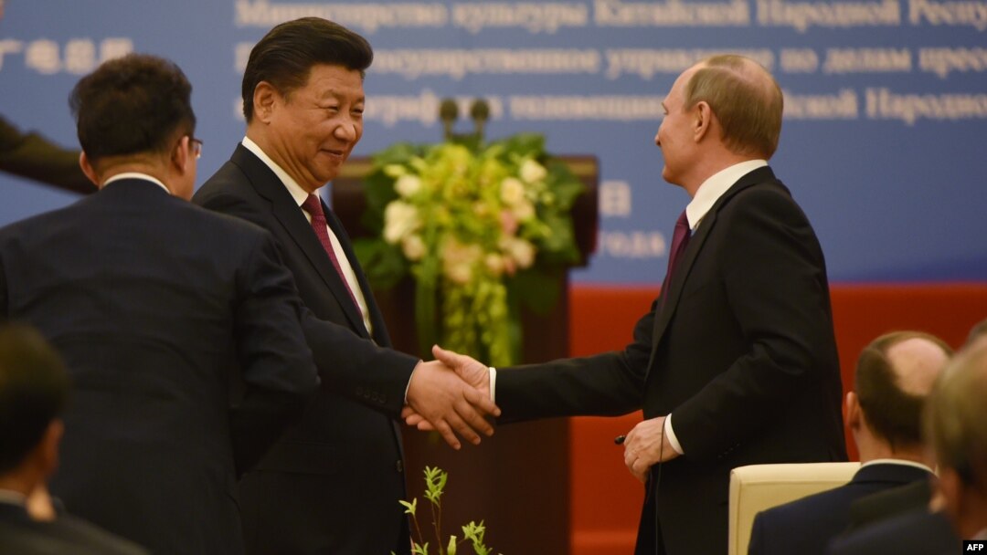 Chinese President Xi Jinping (left) shakes hands with Russian President Vladimir Putin during a ceremony marking the 15th anniversary of the signing of the China-Russia Treaty on Good Neighborliness, Friendship, and Cooperation, in Beijing's Great Hall of the People on June 25.