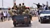 Sudanese antigovernment protesters cheer as they drive towards a military vehicle after Sudan's defense minister said that President Omar al-Bashir had been detained "in a safe place" and that a military council would run the country. 