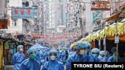 Védőruhás egészségügyi dolgozók Hongkong egy, a koronavírus miatt lezárt negyedében, 2021. január 23-án. 