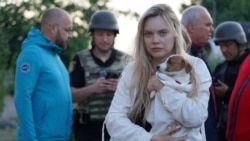 A resident holds her dog at the site of an apartment building damaged during Russian drone and missile strikes on the town of Smila in Ukraine's Cherkasy region.