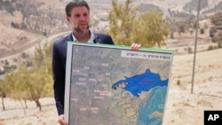  Израелският министър на финансите Бецалел Смотрич, който е измежду крайнодесните представители в държавното управление, държи карта на плана за нови израелски селища в Западния бряг, 14 август 2025 година 