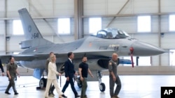 Presidenti ukrainas, Volodymyr Zelenskyy (i dyti nga e djathta) dhe kryeministri holandez në detyrë, Mark Rutte (në mes) duke e shikuar avionin luftarak F-16 në Eindhoven, Holandë, gusht 2023.