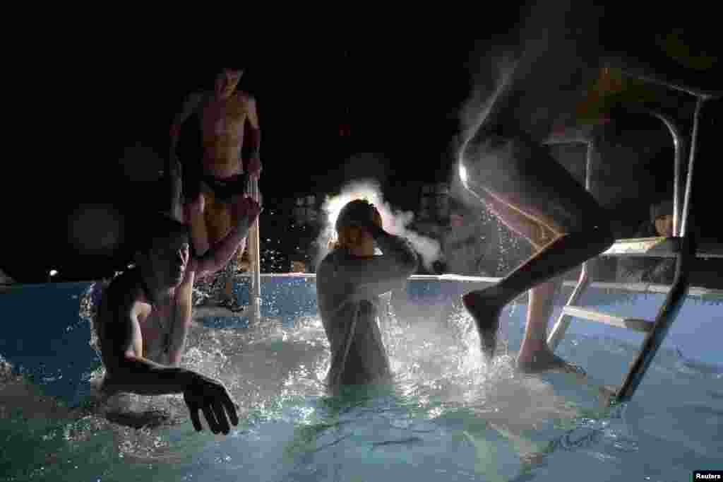 Believers immerse themselves in a pool outside an Orthodox church in eastern Russia with temperatures around minus-20 degrees Celsius. The Russian Orthodox Church celebrates Epiphany on January 19 in line with the Julian calendar. (Reuters/Yuri Maltsev)