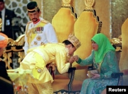 Султан Брунея (слева), его сын и жена, 1998 год. Фото: Reuters
