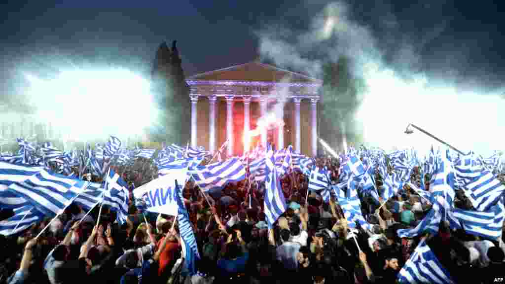 Supporters of conservative New Democracy party leader Antonis Samaras wave flags during a preelection speech in Athens. (AFP/Aris Messinis)