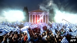 Supporters of the leader of the conservative party New Democracy, Antonis Samaras, wave flags during a pre-election speech in Athens. 