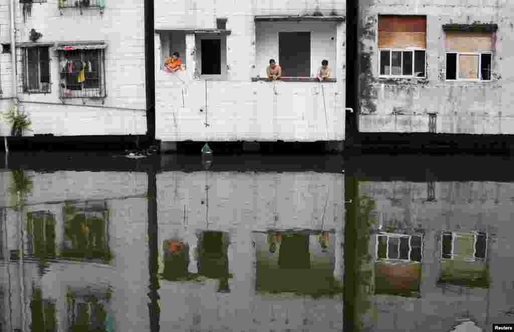 People fish at an abandoned flat in Xian village, a slum area in downtown Guangzhou, China. (Reuters/​Tyrone Siu)
