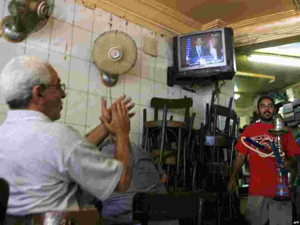 Жители на Египет го следат говорот на Барак Обама - EGYPT, Cairo : An Egyptian man (L) applauds as he listens to US President Barack Obama's speech at Cairo University, at a coffee shop in Cairo on June 4, 2009. Egyptians across the social spectrum hailed Obama's "historic" speech to the world's Muslims, while looking forward to assertive actions in the Middle East.