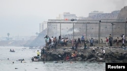 Pe lângă gard, spre Spania. Migranții trec prin mare spre teritoriul spaniol înconjurat cu garduri înalte și sârmă ghimpată. 