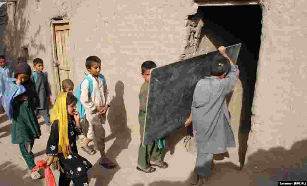 افغانستان: د جلال اباد ښار په څنډو کې افغان ماشومان د خپل ښوونځي ټولګي ته درومي.