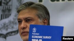 Pakistan's Finance Minister Ishaq Dar shows a copy of the economic survey of fiscal year 2014-2015 during a news conference in Islamabad in June 2015.