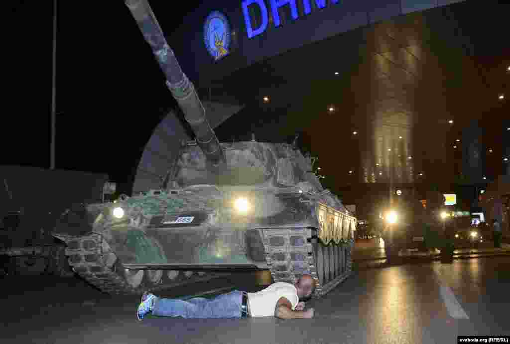 A man lies in front of a Turkish Army tank at Ataturk airport in Istanbul. As flights were suspended, Turkish Airlines took to Twitter to condemn the attempted coup, saying, &quot;Citizens who believe in democracy and freedom to stand up against this attack on our Parliament and our public representatives.&quot;