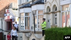 A police officer stands on duty outside a residential property in Manchester as investigations continue into a deadly bomb attack earlier this week. 