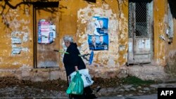 Жінка йде повз агітаційні плакати кандидатів у президенти, Болгарія, 11 листопада 2016 року